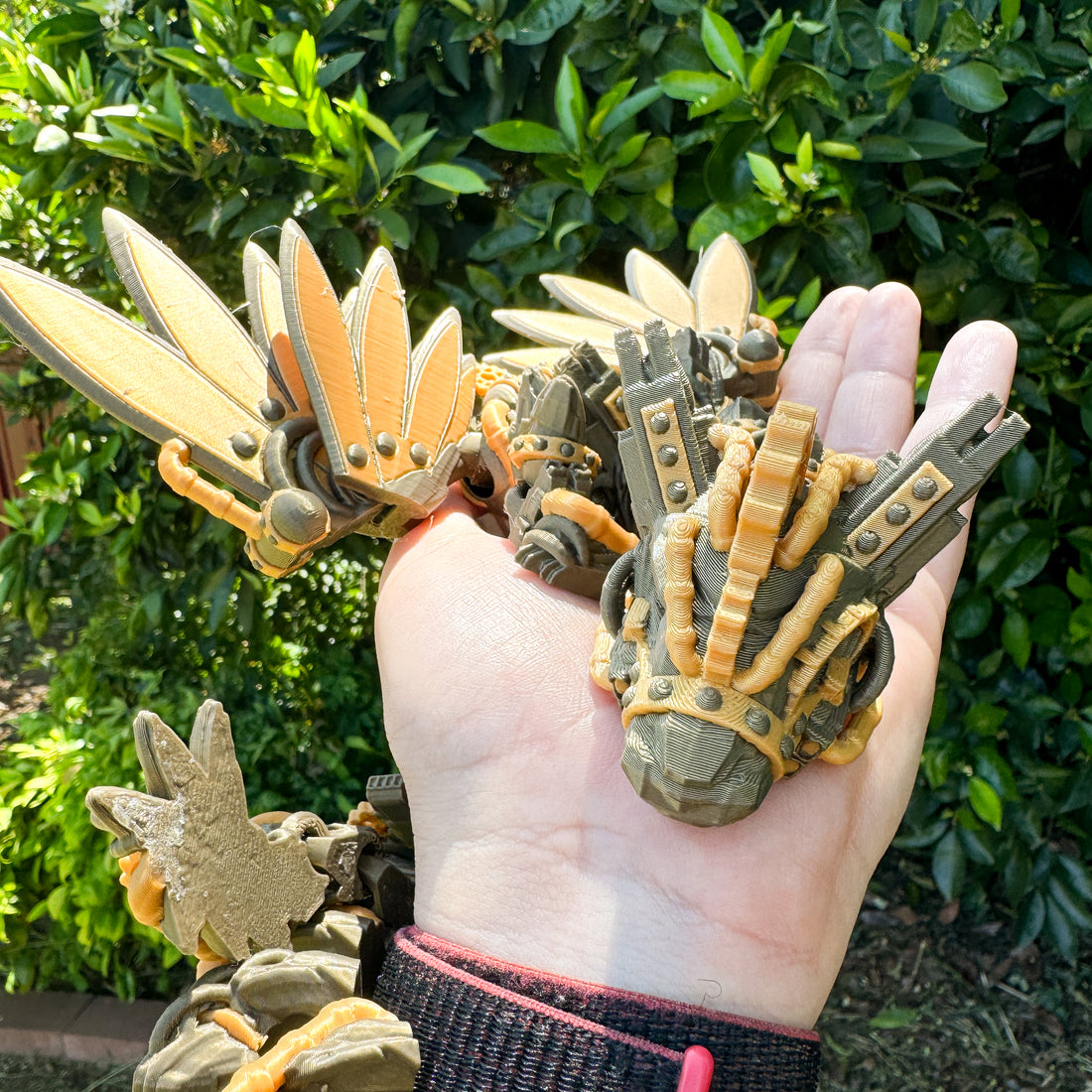 a hand holding a bunch of small toy dinosaurs