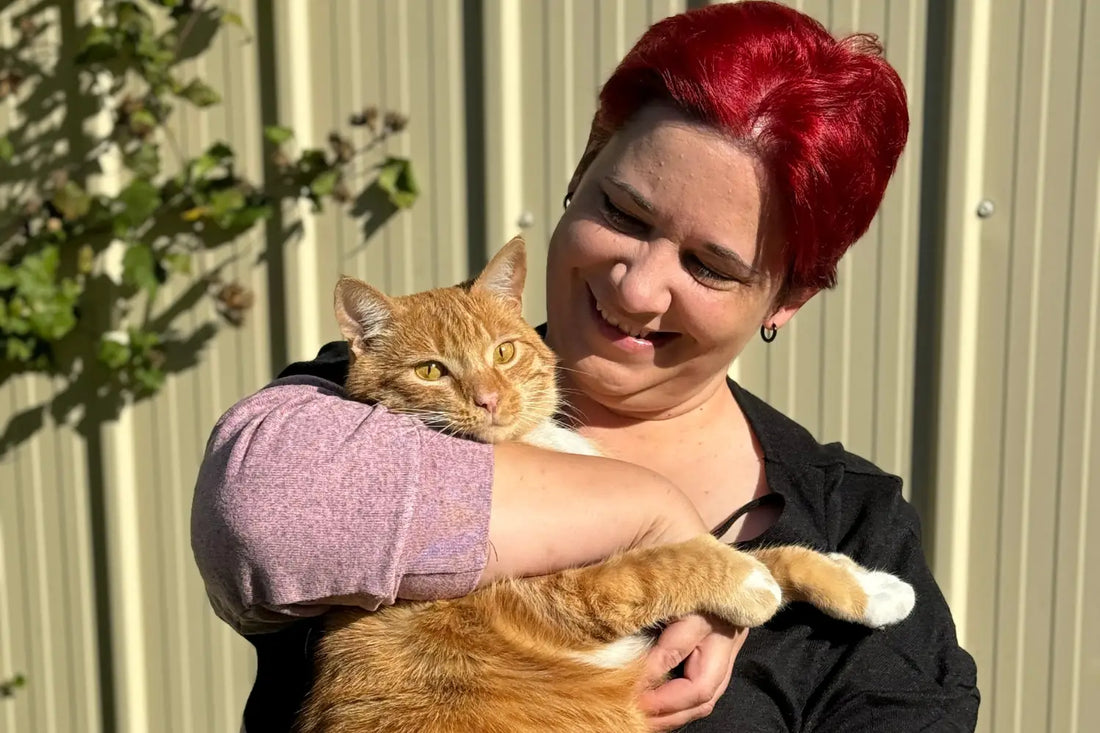 a woman with red hair holding a cat