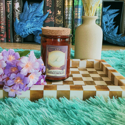 Caramilk candle on chequered board with flowers