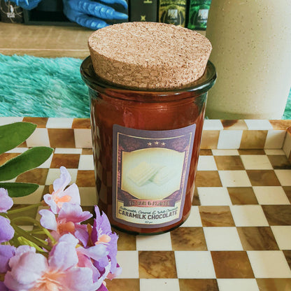 Caramilk candle on chequered board with flowers