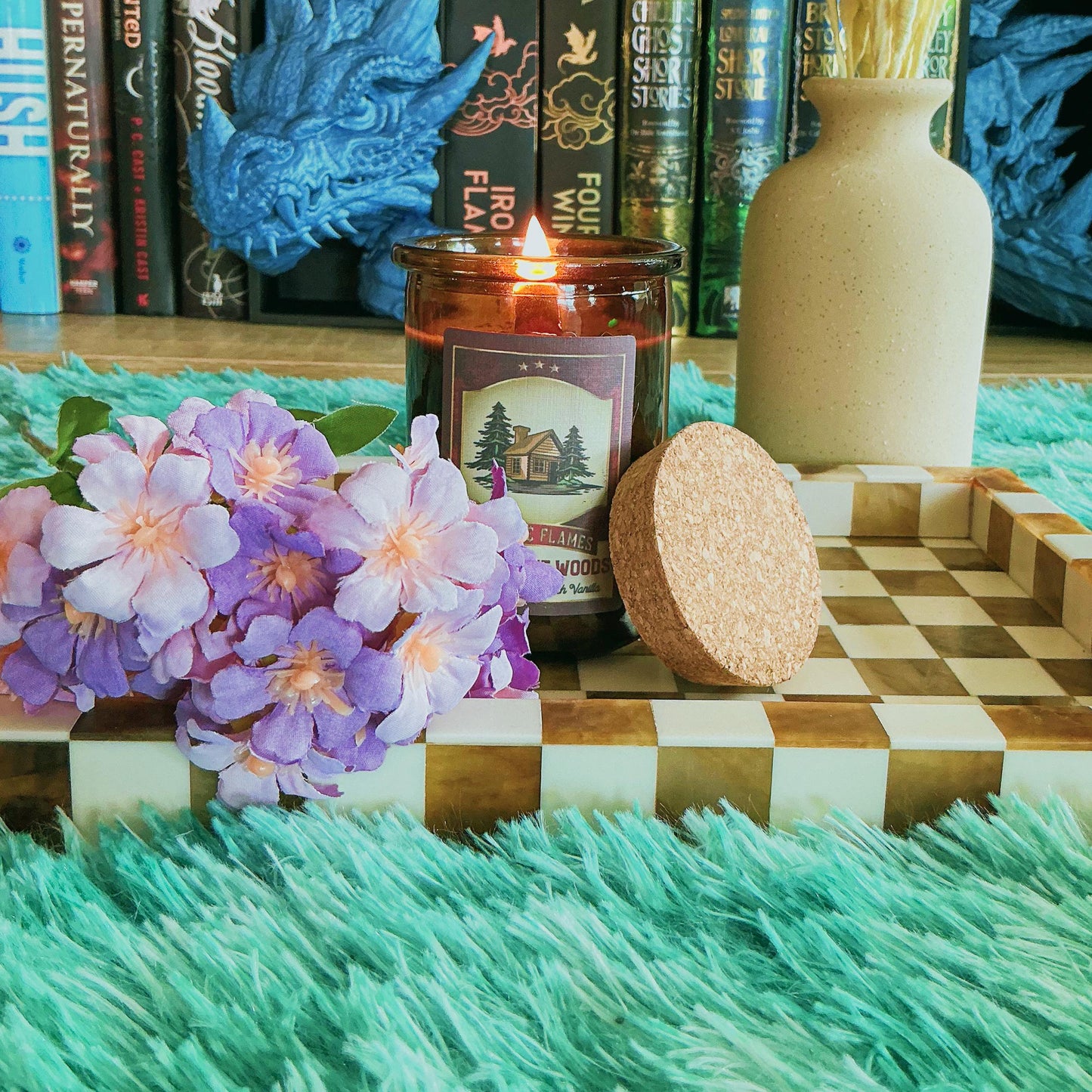 Cabin in the woods candle on chequered board with flowers