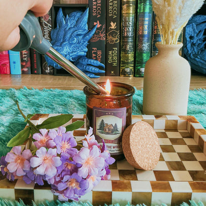 Cabin in the woods candle on chequered board with flowers