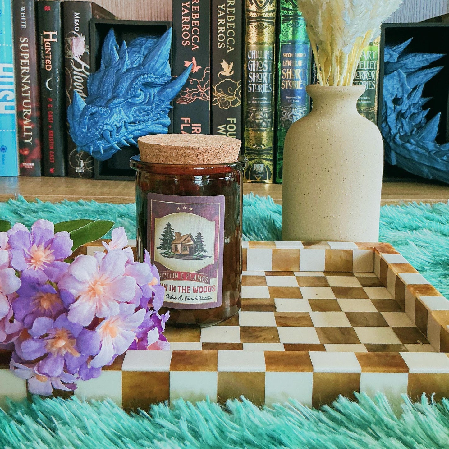 Cabin in the woods candle on chequered board with flowers