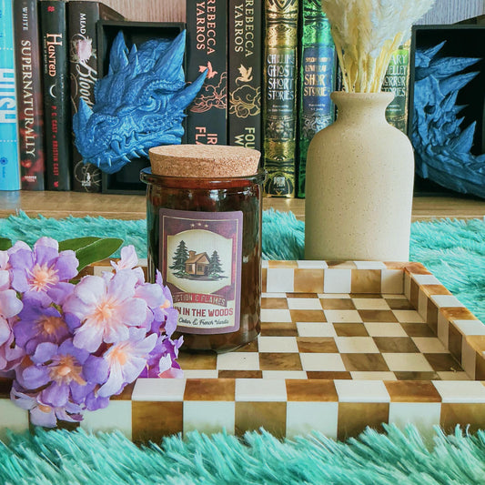 Cabin in the woods candle on chequered board with flowers