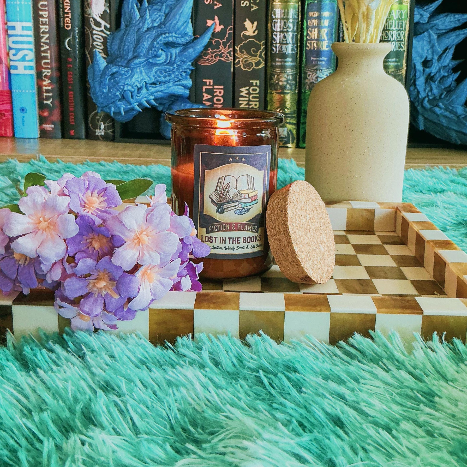 Lost in the books Candle on a chequered board with flowers