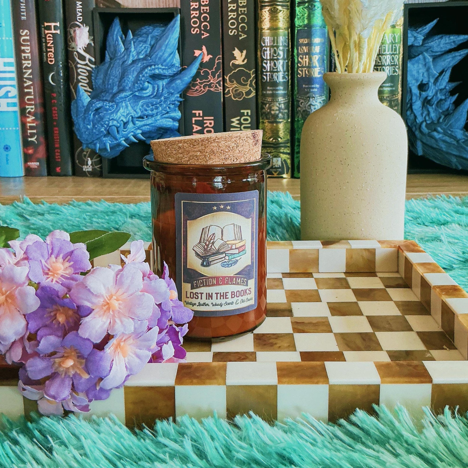 Lost in the books Candle on a chequered board with flowers