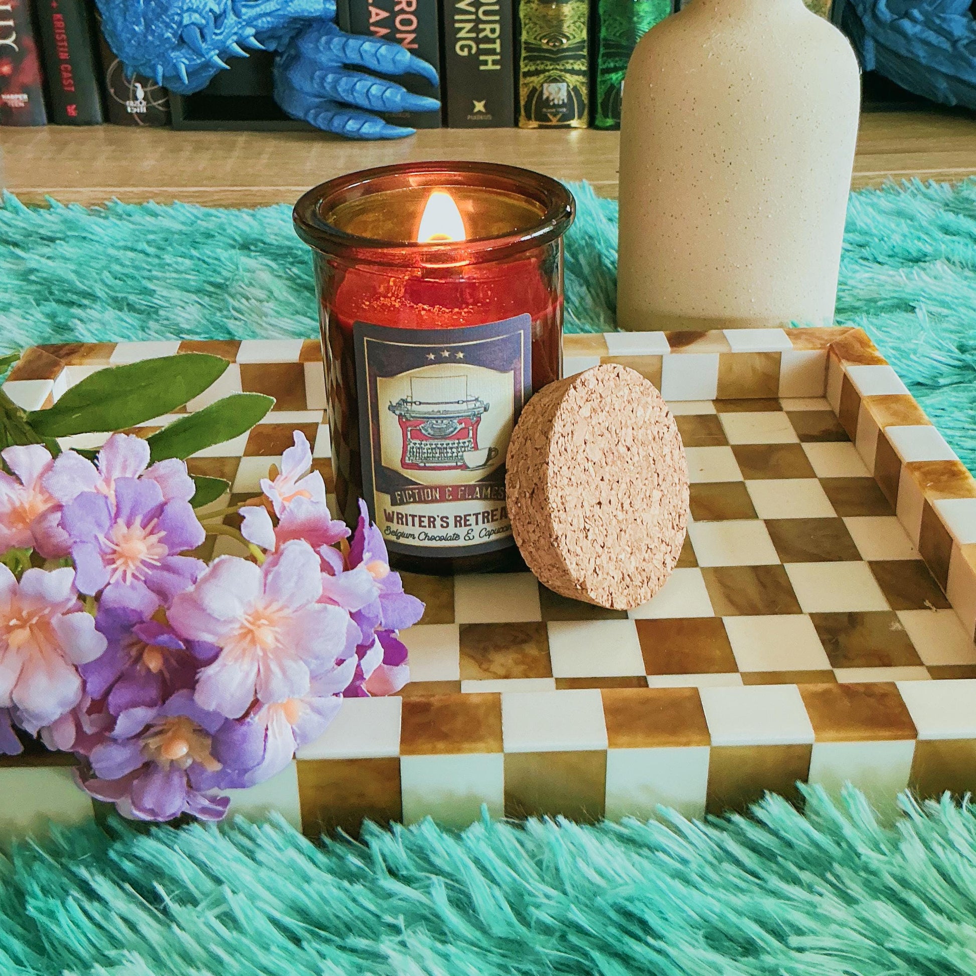 Writers Retreat candle on chequered board with flowers