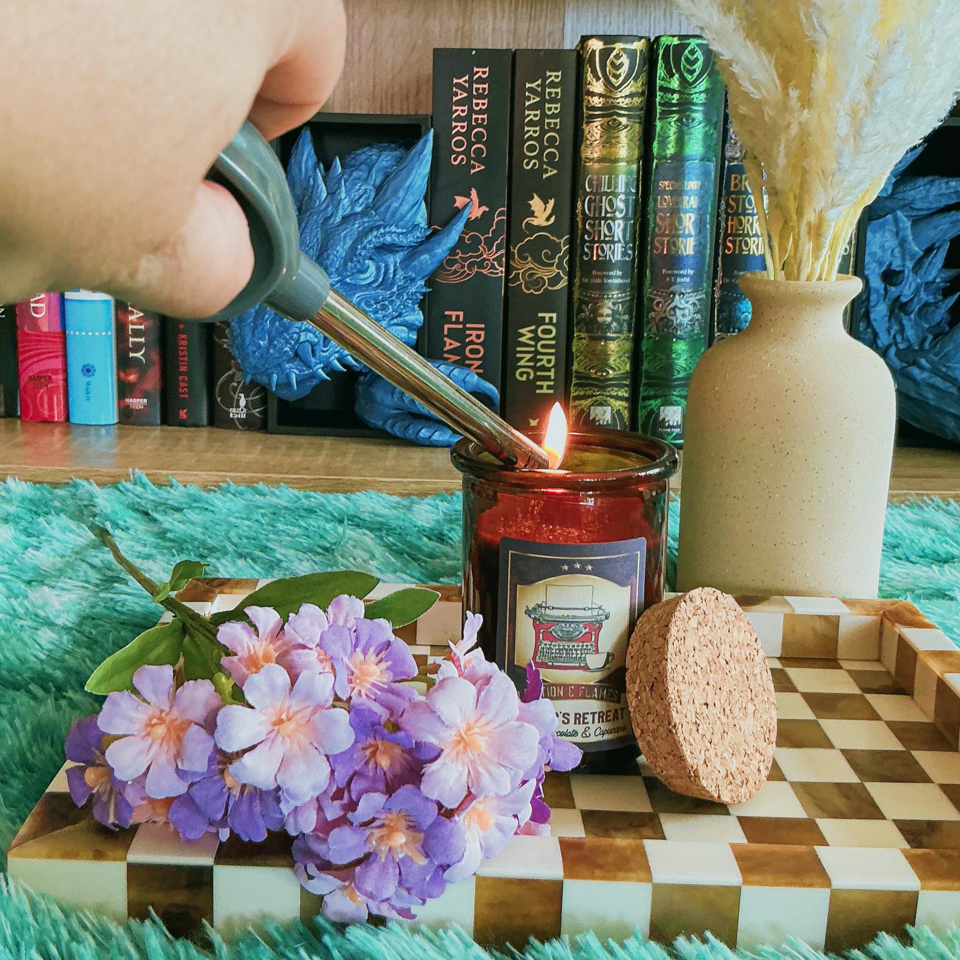 Writers Retreat candle on chequered board with flowers