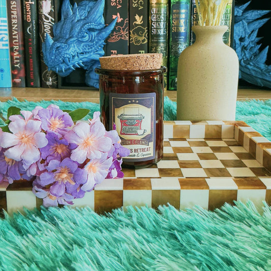 Writers Retreat candle on chequered board with flowers